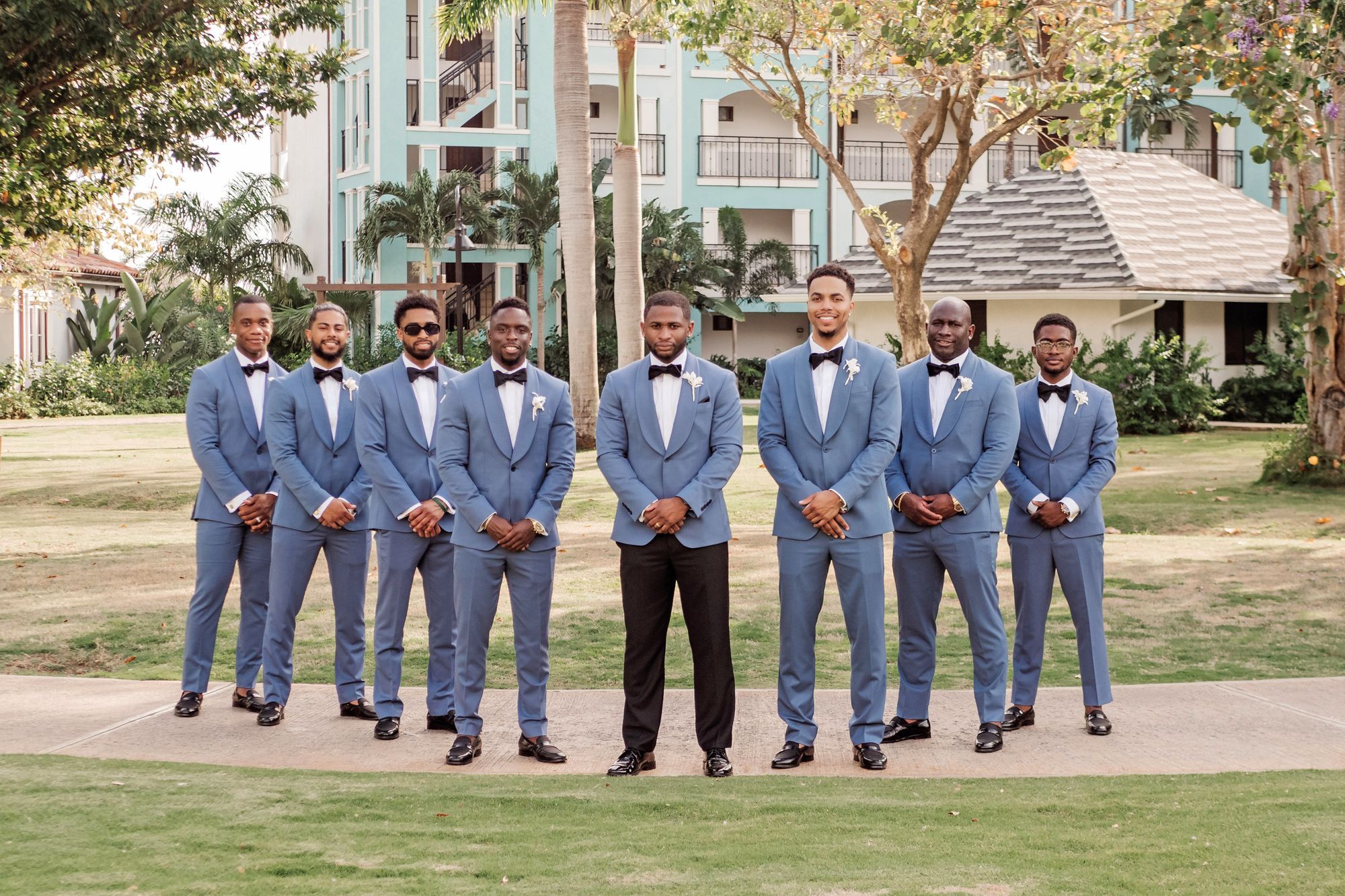 groom and groomsmen posing in blue suits