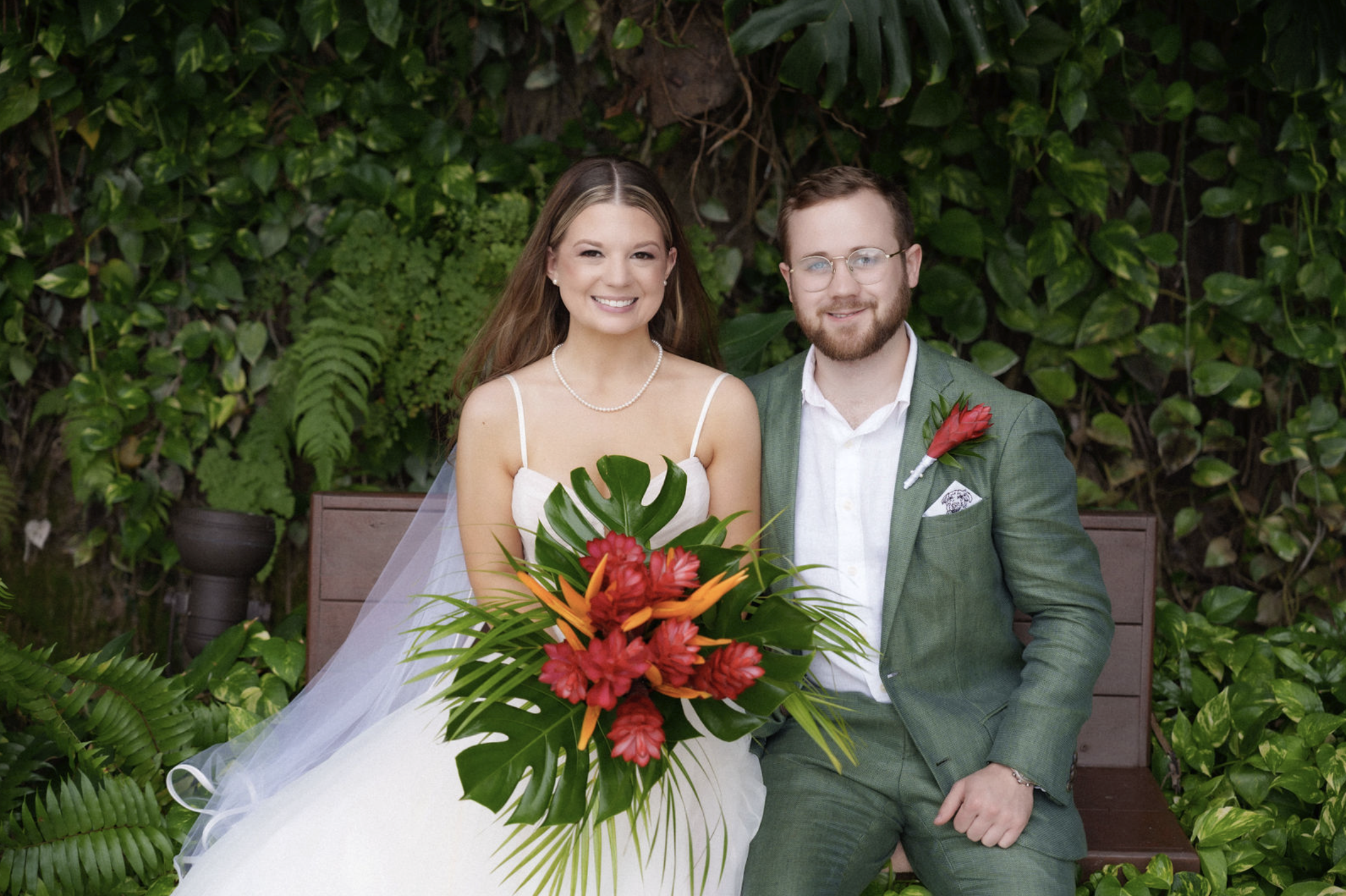 hailey-and-caleb-sitting-on-bench-in-wedding-attire
