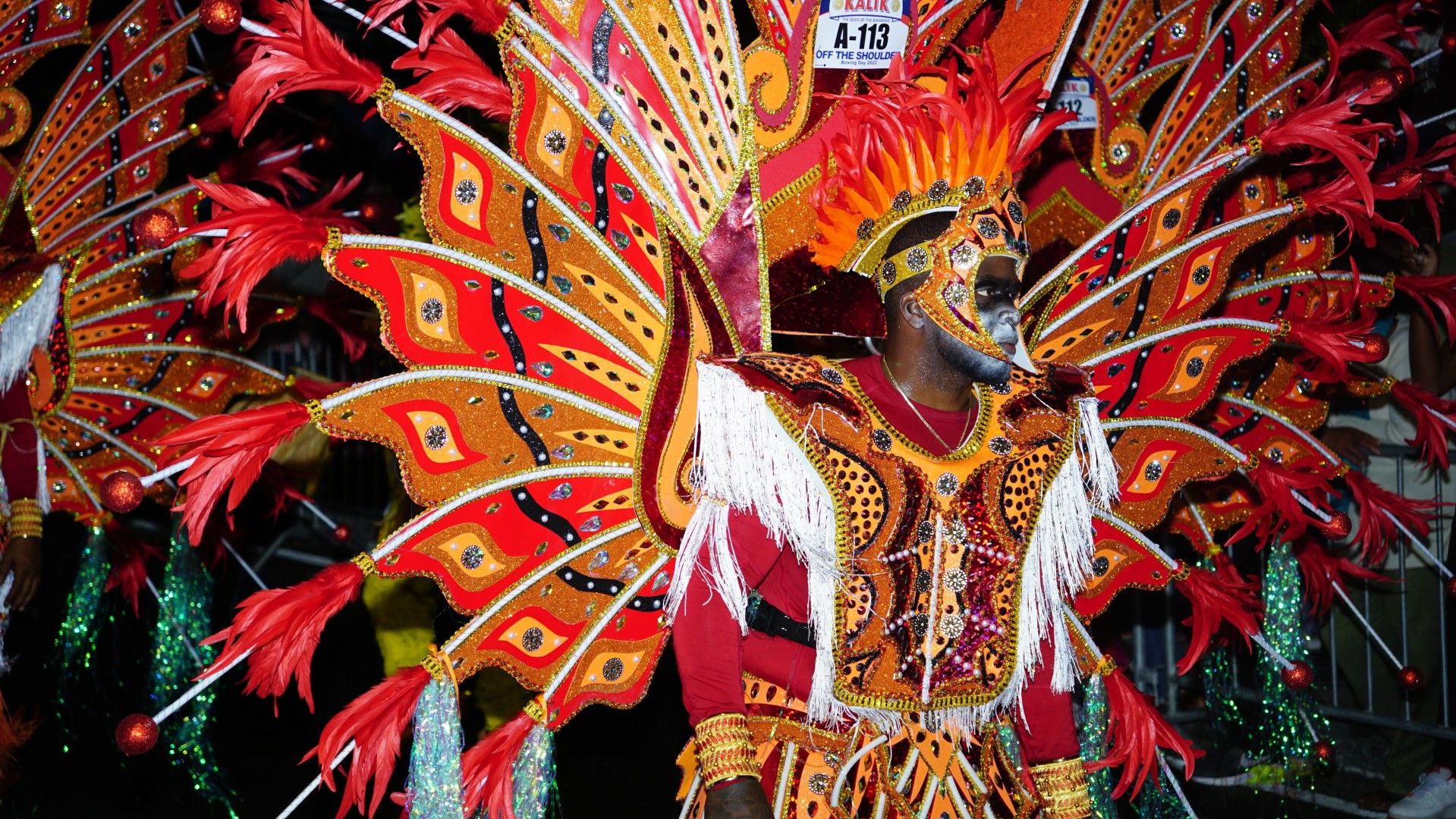 Young man dressed bright red colorful costume for the annual Boxing Day Junkanoo street parade, The Bahamas
