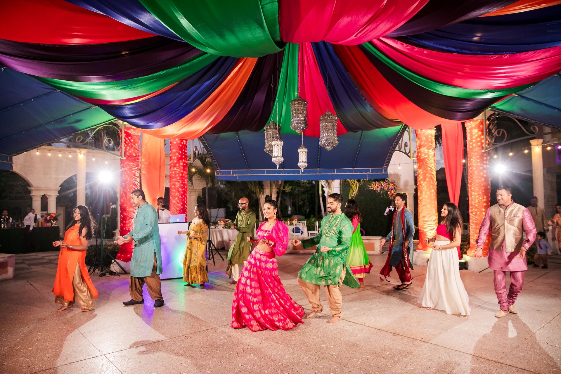 Guests dancing together under colorful draped décor at a destination celebration