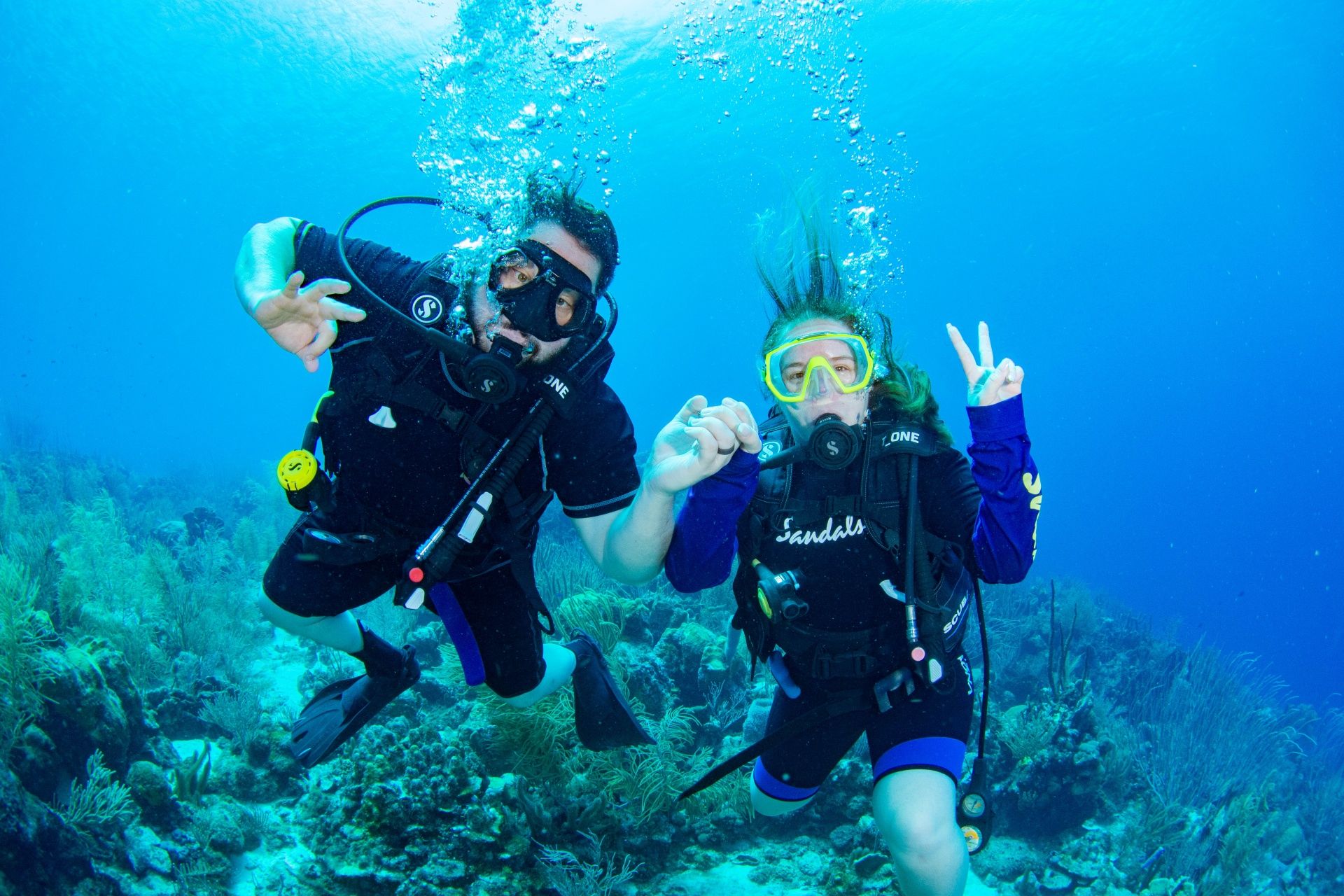 Couple scuba diving together in clear Caribbean waters