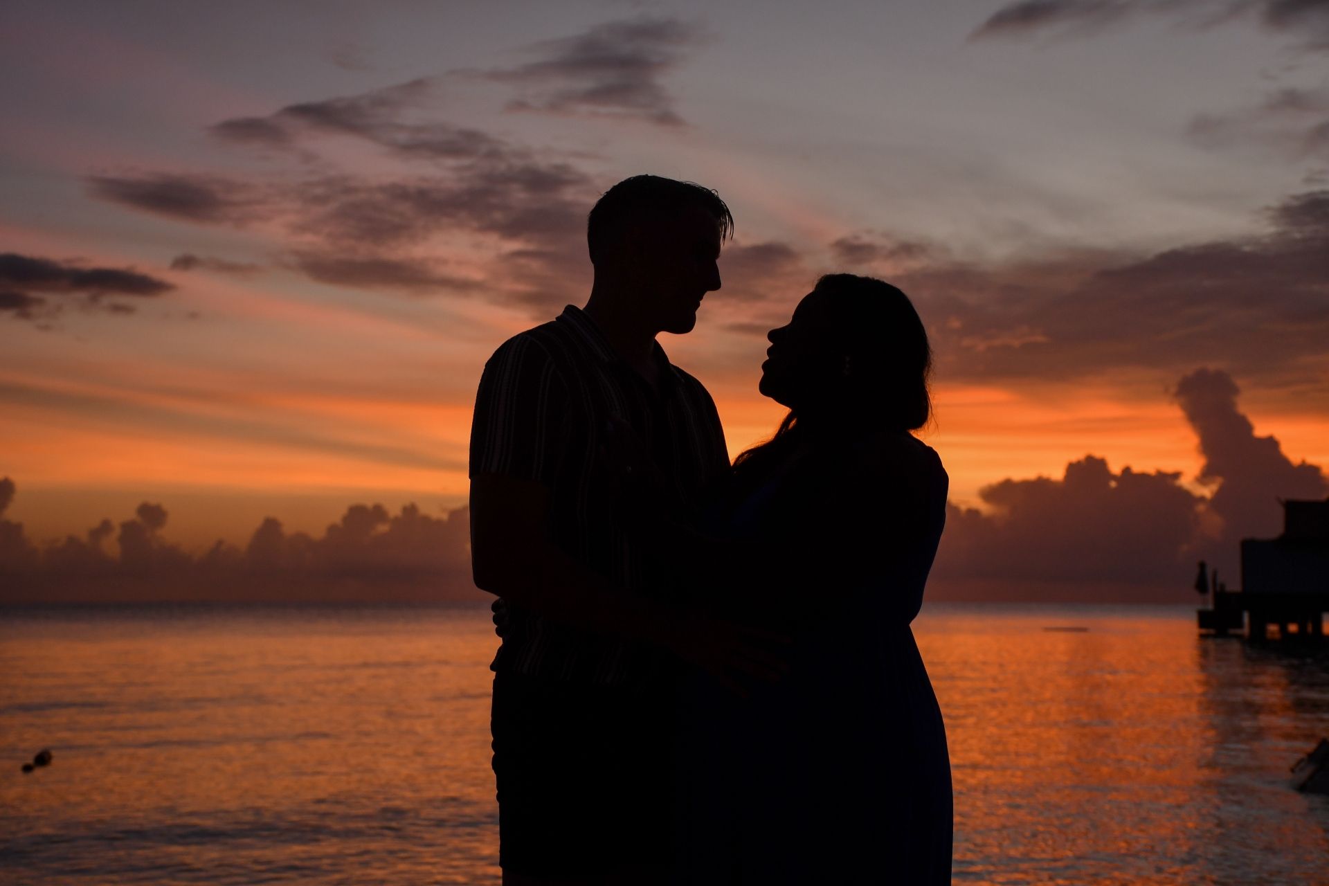 Silhouette of expecting couple at sunset during their babymoon in Jamaica